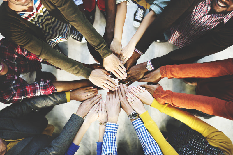 Many people with their hands clasped in a circle